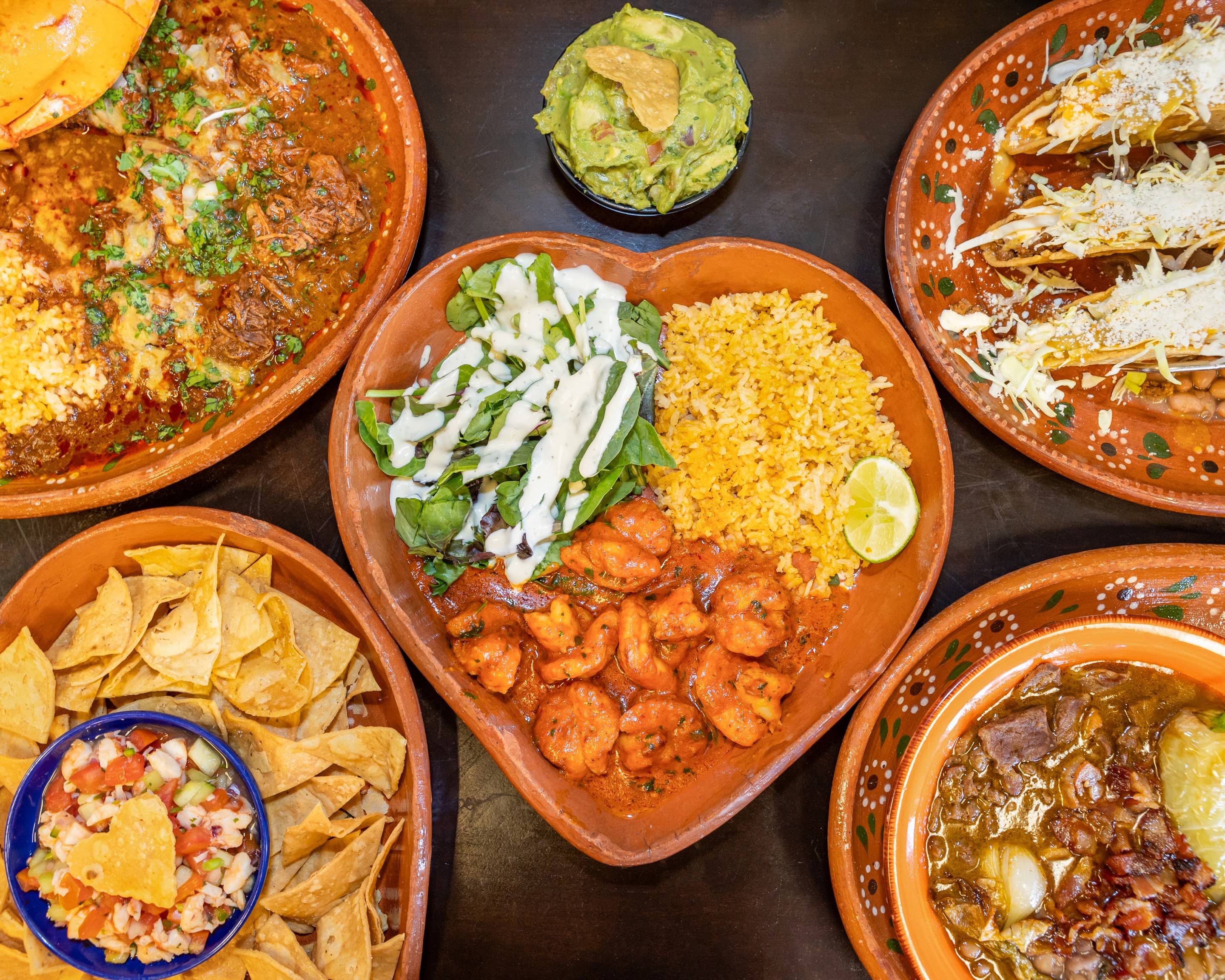 Overhead spread of Carolina's dishes served on heart-shaped clay plates