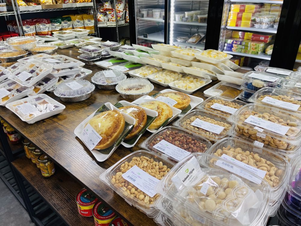 A long table of packed kakanin, breads and Filipino snacks ready for pasalubong
