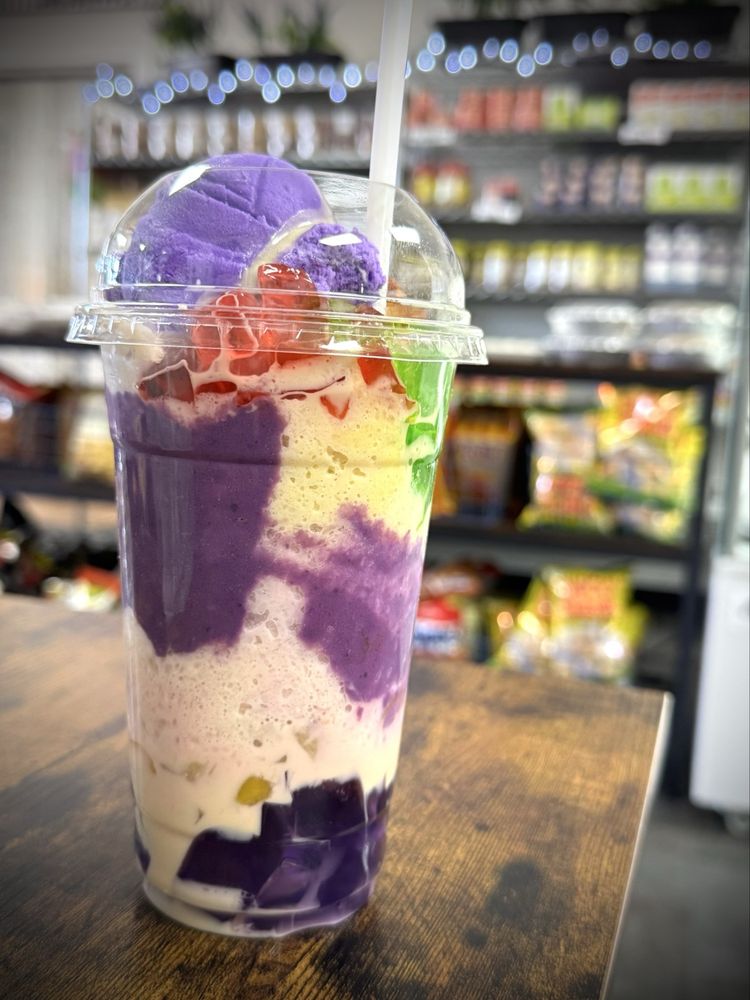 Halo-halo with a purple ube scoop and layers of colorful toppings, with the market shelves behind