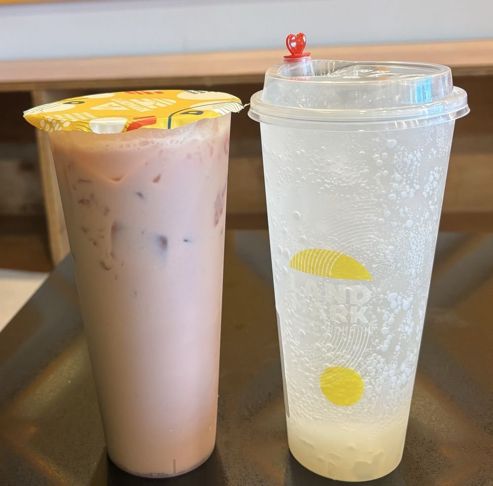 Lychee Sparkling beside a milk tea